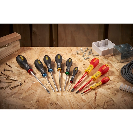 STANLEY 0-65-337 screwdriver set with black and red handles on a workshop table, photographed overhead.