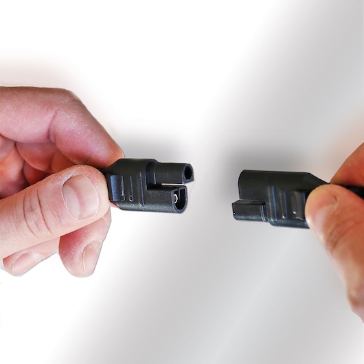 Photo of STANLEY SXAE00026GB black connector cable held by two hands, product photography on white background.