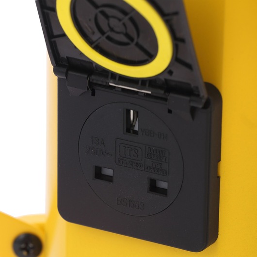 STANLEY SXLS31322E close-up of black UK power socket with hinged protective cover on yellow background.