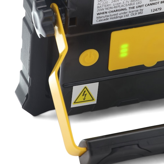 STANLEY SXLS31330E work light handle close-up, showing yellow power button, battery indicator, and caution symbol.