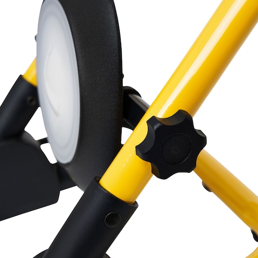 STANLEY SXLS35525E work light close-up, yellow frame, black adjustment knob and round lamp, studio angle.