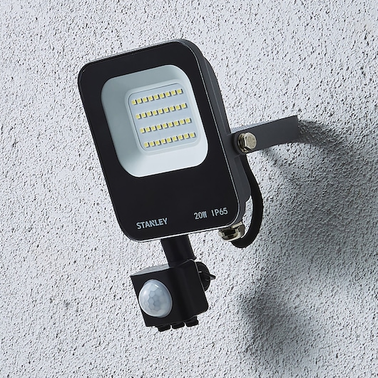 STANLEY SXLS38687E LED floodlight with motion sensor, mounted on wall, front angle.