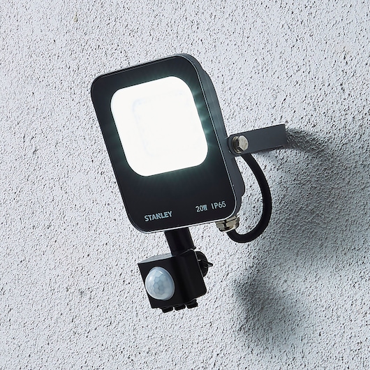 STANLEY SXLS38689E LED floodlight with motion sensor, mounted on wall, front angle, black housing.