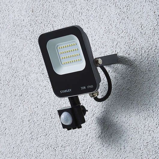 STANLEY SXLS38689E outdoor LED floodlight with sensor, mounted on textured wall, side angle.