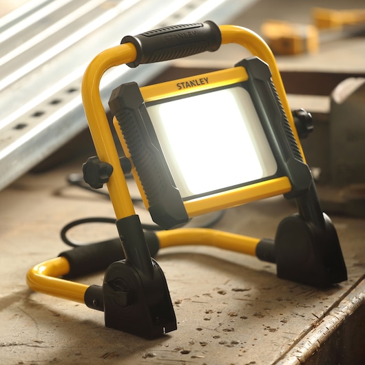 STANLEY SXLS41219E portable work light with yellow frame and black accents, angled on a workshop table.