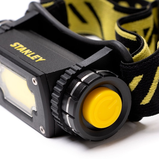 STANLEY SXLS50100E headlamp with adjustable black and yellow strap, side angle on white background.