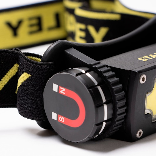 STANLEY SXLS50100E LED headlamp close-up, showing black and yellow headband with magnet feature icon.