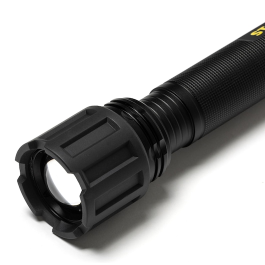 STANLEY SXLS50103E black flashlight close-up, showing textured grip and rugged lens housing, studio angle.