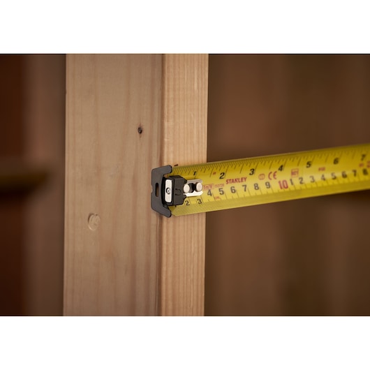 STANLEY XTHT0-33503 tape measure extended on wood, close-up side angle.
