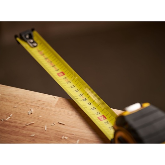 STANLEY XTHT0-33671 tape measure extended across wooden surface, close-up photography.